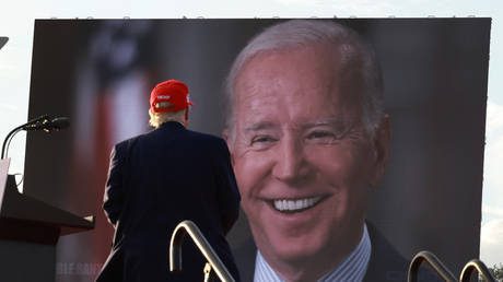 Former US President Donald Trump watches a video of President Joe Biden playing during a rally on November 6, 2022 in Miami, Florida
